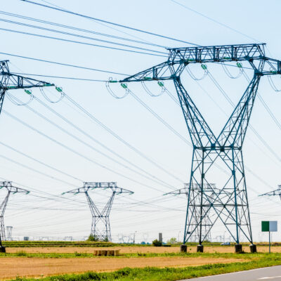 Panoramic view of a row of electricity pylons in the countryside.