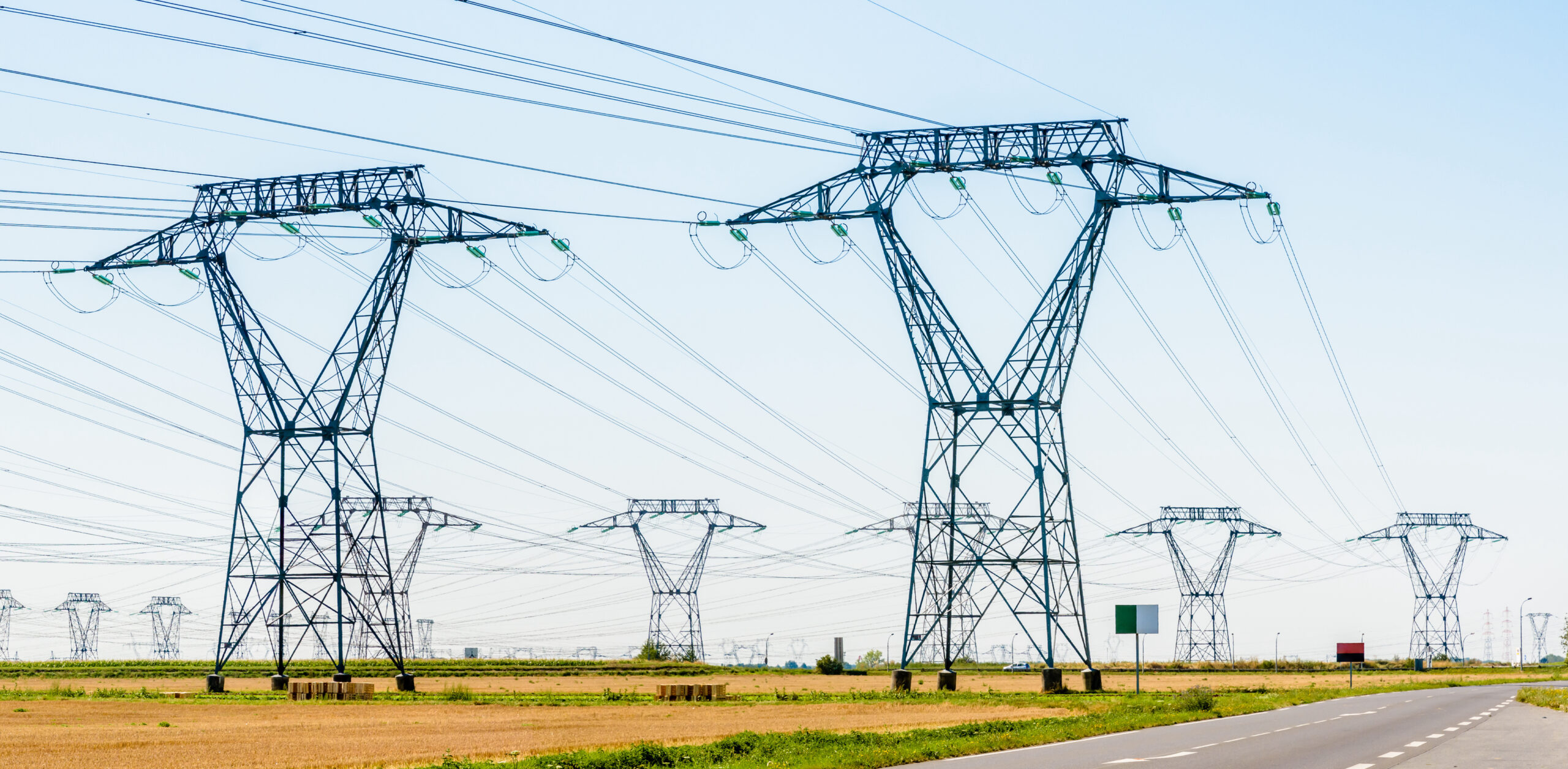 Panoramic view of a row of electricity pylons in the countryside.
